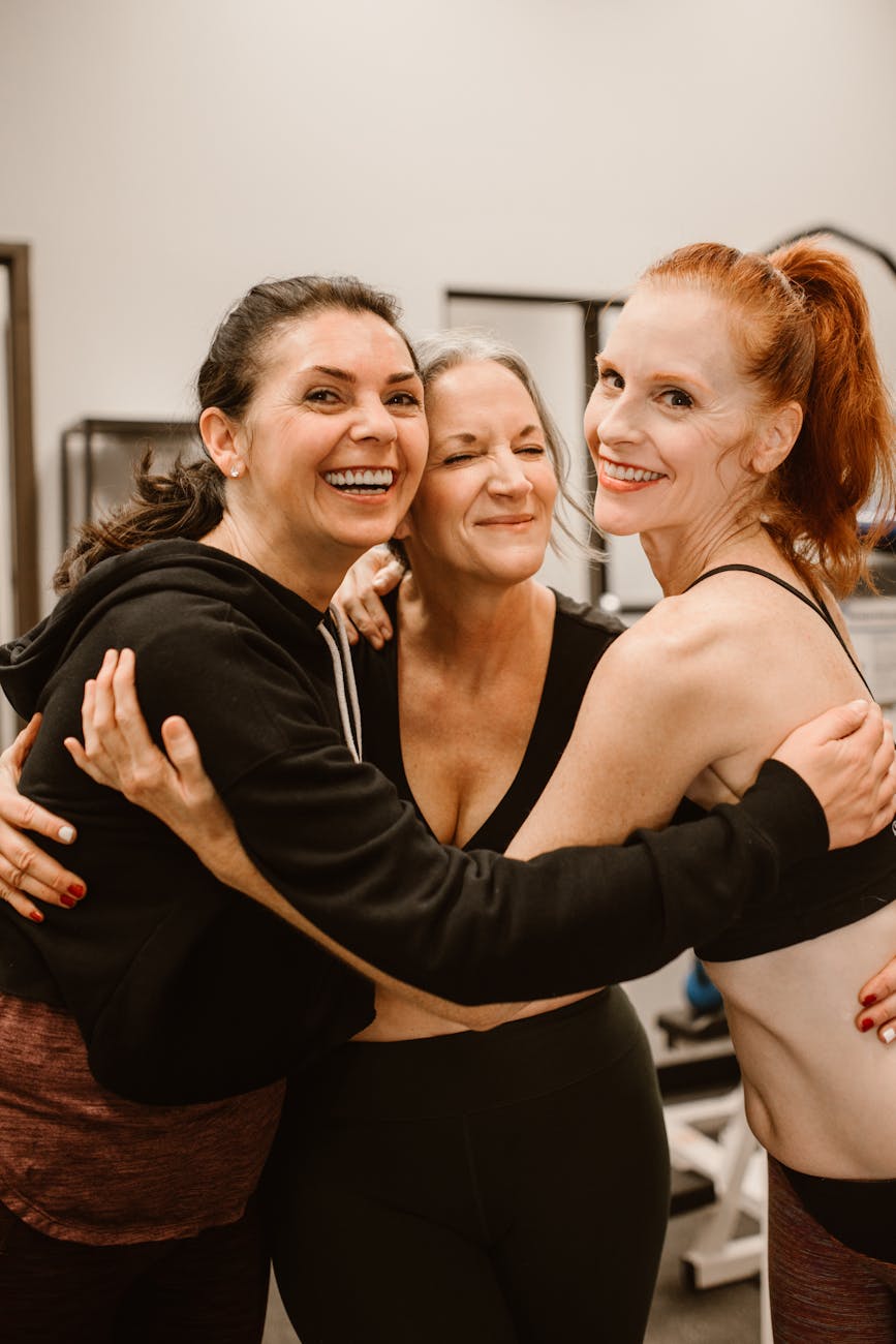 Women hugging and supporting each other at gym